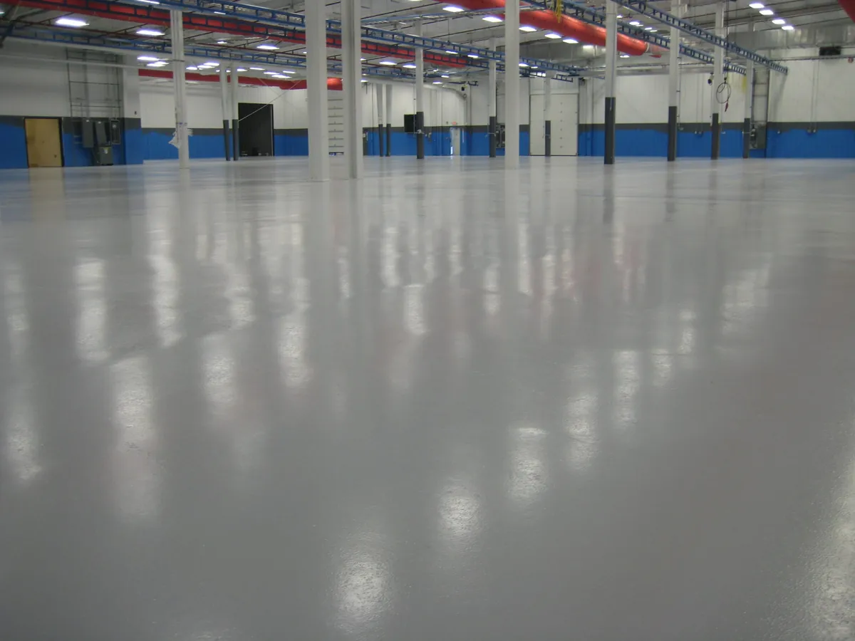 Glossy gray commercial epoxy floor coating in a large open building